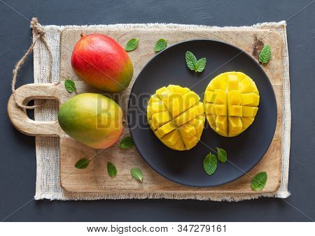Mango Cut In Half And Cubed On A Wooden Board, Two Whole Mango, Rustic Background, Top View