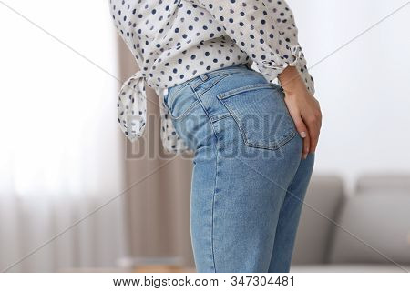 Young Woman Suffering From Hemorrhoid At Home, Closeup