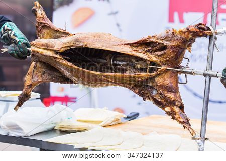 The Carcass Of A Lamb Is Roasted On A Spit. Close-up Carcass Of A Sheep That Is Roasting On The Spit
