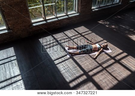 Young Fit Calm Mindful Sporty Woman Practicing Yoga Exercise Lying With Eyes Closed In Dead Body Cor