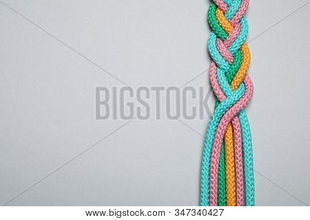 Top View Of Braided Colorful Ropes On Light Grey Background, Space For Text. Unity Concept
