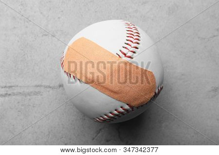 Ball With Sticking Plaster On Light Grey Stone Table, Top View