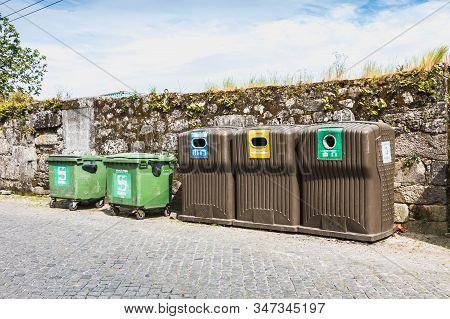 Public Recycling Bins In Front Of A Stone Wall In Vila Cha, Portugal