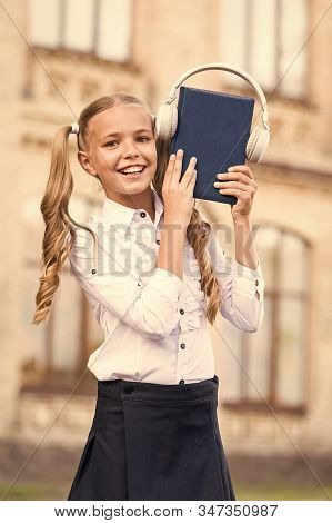 Elearning And Modern Methods. Girl Cute Schoolgirl Hold Book And Headphones. Knowledge Assimilate Be