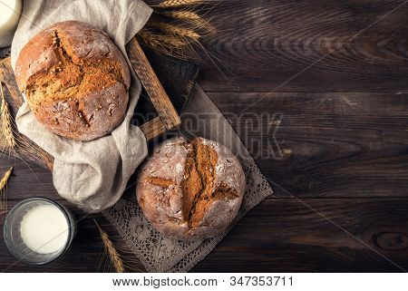 Homemade Rye Bread With Coriander Seeds And A Glass Of Milk On Rustic Wooden Background. Top View. S