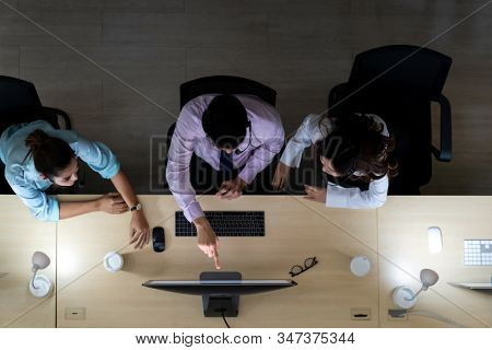 Late Night Environment, Top view of young adult friendly operator team with headsets discussing about customer case in a call center customer service and technical support. Using for 24 Hr Call center