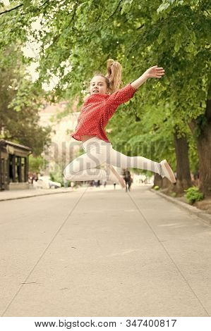 Feeling Really Energetic. Lively Small Girl Jumping With Energetic Moves. Active Kid Being In Energe