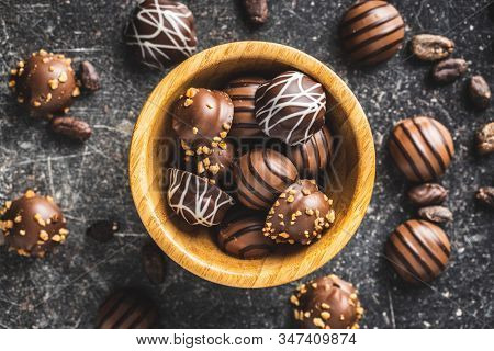 Praline bonbons. Chocolate truffles in wooden bowl.