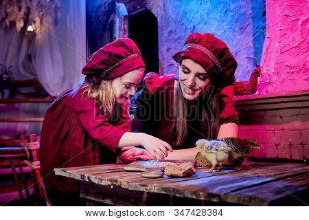 Easter And Family. Mother And Daughter In Maroon Or Red Dresses Of The Village Shepherdesses And Sma
