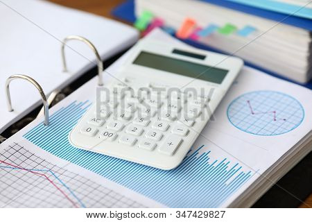 White Caculator With Business Chart Lie On The Office Table Background Closeup. Financial Education 