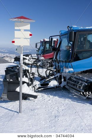 Dwa snowcat i szyld.