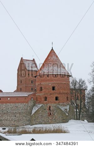Gothic Red Brick Trakai Castle In Winter Time, In The Middle Of Frozen Lake, Lithuania