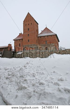 Gothic Red Brick Trakai Castle In Winter Time, In The Middle Of Frozen Lake, Lithuania