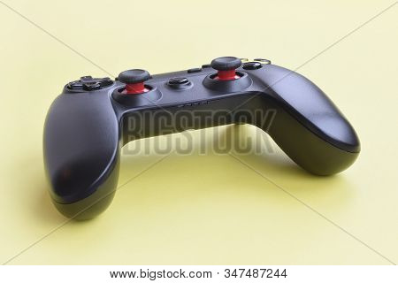Modern Black Joystick On Yellow Background. Gameplay Streaming And Video Game Walkthroughts Concept
