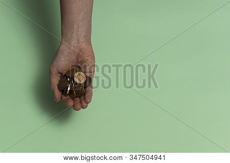 The Female Hand Holds In One Palm A Handful Of Cash Coins - The New Israeli Shekel, Agorot. Light Gr