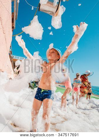 Russia, Tuapse July 4, 2019: Foam Party. Children Have Fun At A Foam Party On The Beach.