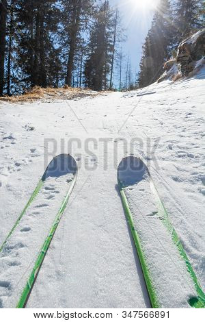 Ski Tourer Ascending A Snowy Road Through Forest.