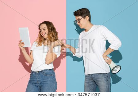 Shes Taking Selfie, Hes Trying To Pay Attention. Young And Happy Man And Woman On Pink, Blue Backgro