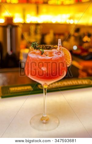 Cocktail With Dried Lemon, Raspberries And Ice On The Bar. Bright Red Cocktail With Foam