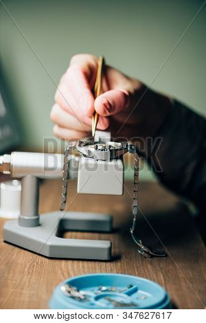 Cropped View Of Watchmaker Repairing Wristwatch By Tool Tray On Table