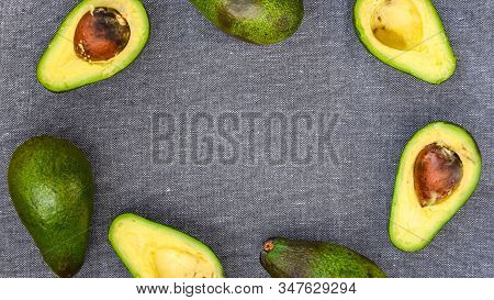 Opened Avocado Showing Seed On Textured Grey Linel Background. Top View, Copy Space, Organic Healthy