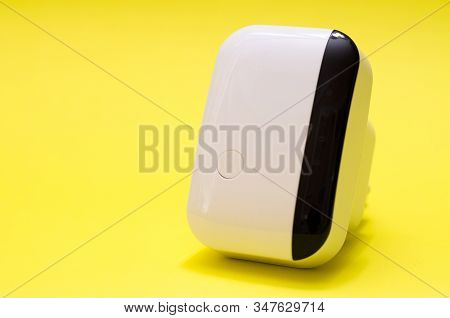 Wireless Wifi Repeater On Yellow Background Close-up