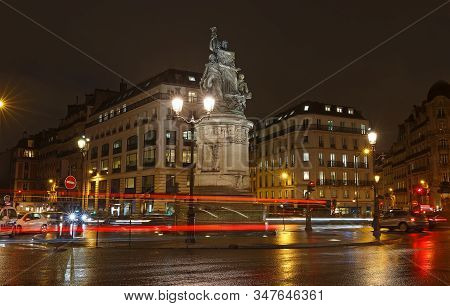 Place De Clichy At Rainy Night , Paris. Bronze Statue Of Marechal Moncey At The Centre Of The Square