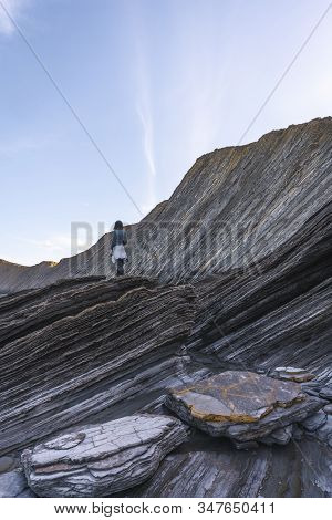 Deba, Gipuzkoa / Spain »; January 26, 2020: A Young Woman Standing On Top Of Some Stones In The Geop