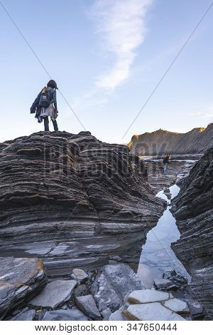 Deba, Gipuzkoa / Spain »; January 26, 2020: A Young Woman On Top Of Some Stones In The Geopark Of Th