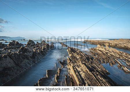Long Exposure Geopark In Sakoneta On The Coast Of Deba At Low Seas Between Rocks. Basque Country