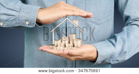 Growing Coins House On Stack Coins In Hand. Concept Of Investment Propert
