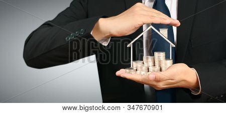 Growing Coins House On Stack Coins In Hand. Concept Of Investment Propert