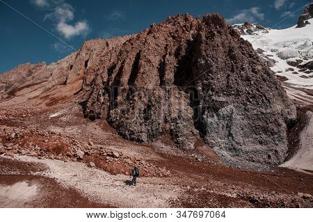 Man Walking On The Dirty Path Looking Up Climbing On The Mountain