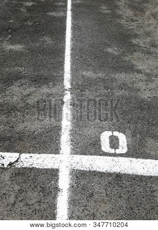White Marking Lines And Numbers On The Asphalt Surface.