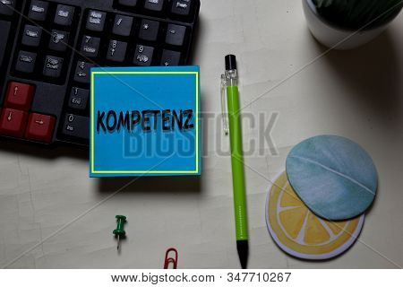 Kompetenz Write On A Sticky Note Isolated On Office Desk. German Language It Means Competence