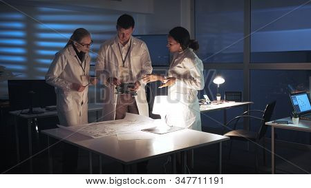 Technology Research Facility: Multiracial Electronics Development Engineers In White Coats Working I