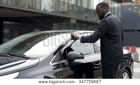 Scrupulous Afro-american Man Wiping His New Car Before Leaving Parking Lot