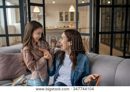 Mom And Daughter Laugh Looking At Each Other.