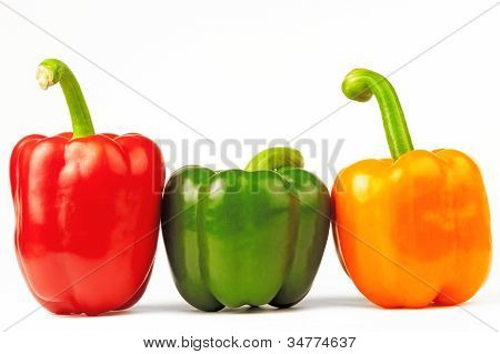 สาม paprikas หลายสีบนพื้นหลังสีขาวแยก