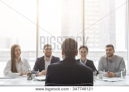 Male Applicant Talking At Job Interview To Hr Comission, Back View, Free Space