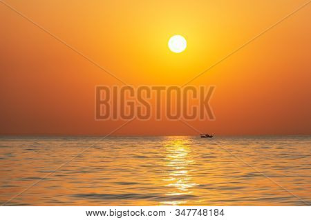 Bright Sunset With Large Yellow Sun Under The Sea Surface. Beautiful Sunset Over The Sea.