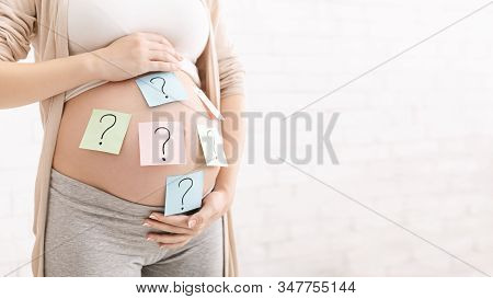 So Mystarable Pregnancy. Pregnant Woman With Question Marks On Paper Stickers On Tummy, Panorama, Em