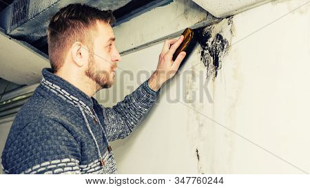 Bearded Man Removes Black Mold On The Wall After Leakage - Image Toned