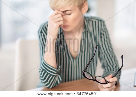 Eyes Fatigue. Mature Businesswoman Having Eyestrain Headache Massaging Nosebridge Sitting At Workpla
