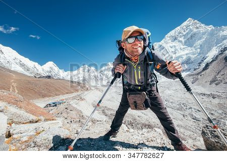 Portrait Of Smiling Hiker Man With Nuptse 7861 M Peak And Gorak Shep Settlement Background With Trek
