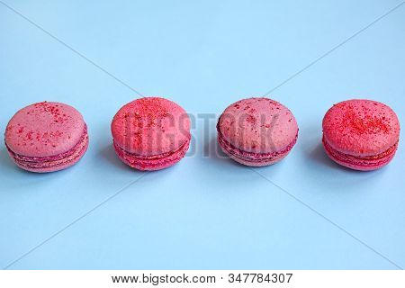 Four Pink Appetizing Macaroons On A Light Blue Background, Top View