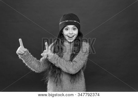 Lots Of Great Deals. Happy Child In Warm Hat Pointing Fingers At Something. Clearance Sale On Kids F