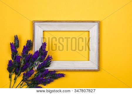 Lavender Twing And Empty Picture Frame On Yellow Background