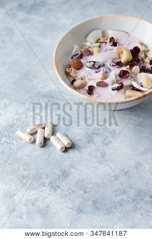Sport Supplements (carnitine Capsules) And Bowl Of Granola With Yogurt, Nuts, Cranberry And Cocoanut