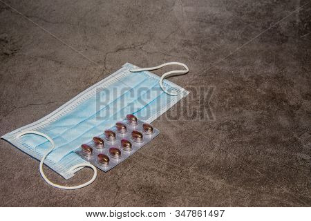 Disposable Surgical Mask And Package Of Medicine On Black Background.